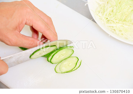 特寫：一位男士正在切黃瓜做沙拉。一系列男士準備飯菜的照片。 130870410