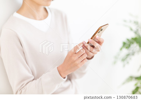 一位隨興的中年女商務女士正在看她的智慧型手機 一位隨興的中年女商務女士正在看她的智慧型手機 130870683