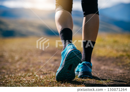 Fitness woman legs walking on high altitude grassland mountain road Fitness woman legs walking on high altitude grassland mountain road 130871264