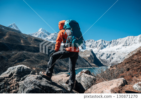 Backpacking woman hiking on high altitude mountain top Backpacking woman hiking on high altitude mountain top 130871270