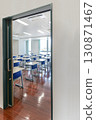 Desks and chairs lined up in a classroom seen from the hallway, school, classroom image 130871467
