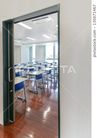 Desks and chairs lined up in a classroom seen from the hallway, school, classroom image Desks and chairs lined up in a classroom seen from the hallway, school, classroom image 130871467