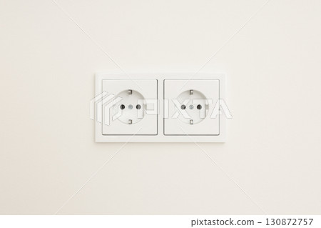 Two standard electrical outlets on a plain wall surface Two standard electrical outlets on a plain wall surface 130872757