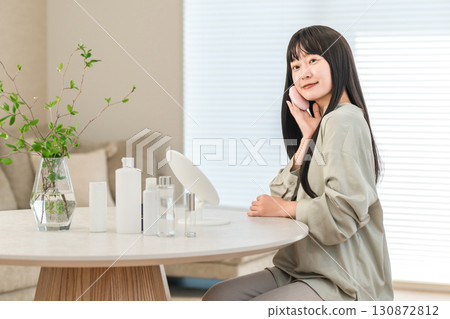 微笑的亞洲女性正在塗抹粉底、粉和化妝品 130872812