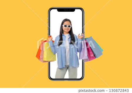 Woman holding shopping bags while looking happy and stylish 130872843