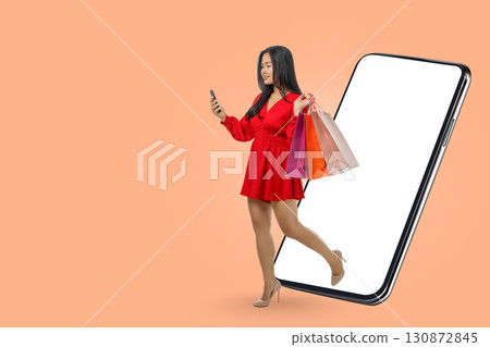 A woman enjoys shopping with colorful bags while using her phone A woman enjoys shopping with colorful bags while using her phone 130872845