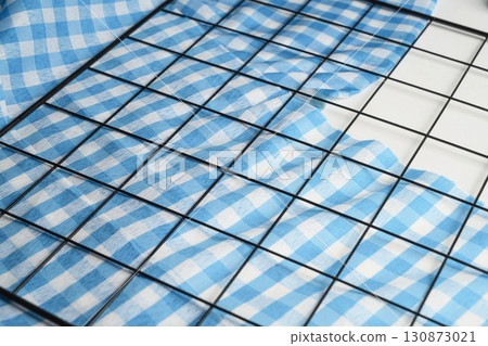 Blue checkered tablecloth or napkin with cooling tray on a white background. Copy space. Concept of Oktoberfest. Bavarian German culture festival decoration symbol 130873021