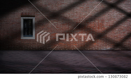 Dramatic shadow of window light shines across the interior of the room with red brick walls and a tile floor. Mockup, copy space, or template. Empty backdrop podium for product or text display 130873082
