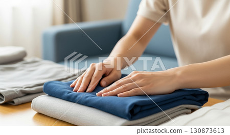 一名年輕女子折疊衣服 — — 房地產組織者 130873613