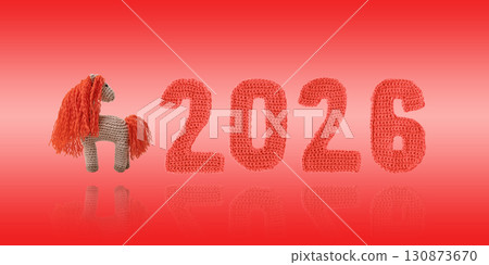 Crocheted toy funny fiery red horse and knitted green numbers. The symbol of the year 2026 on a red background. Chinese New Year greeting card 130873670