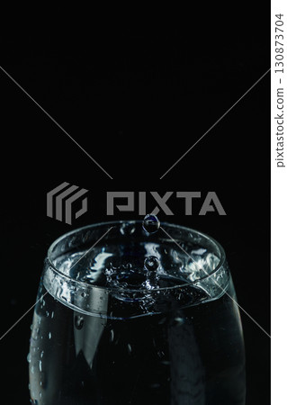 Water overflowing from the glass Water overflowing from the glass 130873704