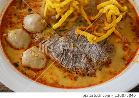 Close up of a beef Khao soi (Northern Thai Coconut Curry Noodle Soup). Khao soi is one of the most popular Thai dishes to eat in northern Thailand, especially in Chiang Mai and Chiang Rai. Close up of a beef Khao soi (Northern Thai Coconut Curry Noodle Soup). Khao soi is one of the most popular Thai dishes to eat in northern Thailand, especially in Chiang Mai and Chiang Rai. 130873840