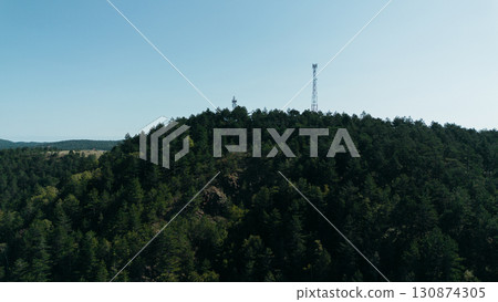 Aerial view of a forested mountain in Divcibare, Serbia, with communication towers on the peak 130874305