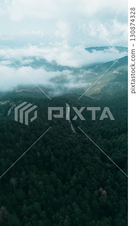 Aerial view over Divcibare, Serbia, showing vast forested hills, valleys, and dramatic clouds above the landscape 130874328