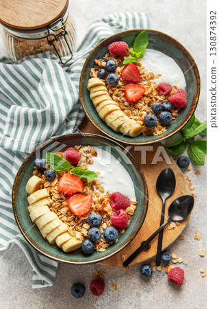 Healthy breakfast bowls with yogurt, granola, banana, and berries Healthy breakfast bowls with yogurt, granola, banana, and berries 130874392