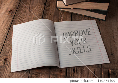 Notebook is open to a page with the words improve your skills written on it Notebook is open to a page with the words improve your skills written on it 130875109