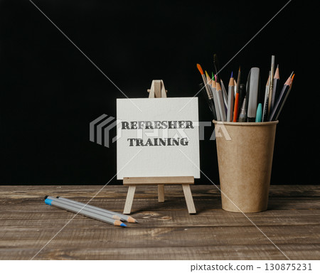 A white board with the word refresher training written on it 130875231