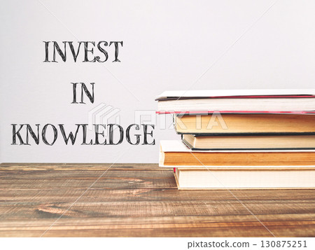 A stack of books with the words invest in knowledge written on top A stack of books with the words invest in knowledge written on top 130875251