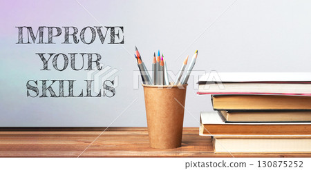 A wooden desk with a cup of pencils and a stack of books A wooden desk with a cup of pencils and a stack of books 130875252