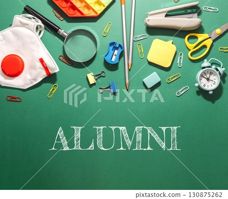 A green chalkboard with a variety of school supplies A green chalkboard with a variety of school supplies 130875262