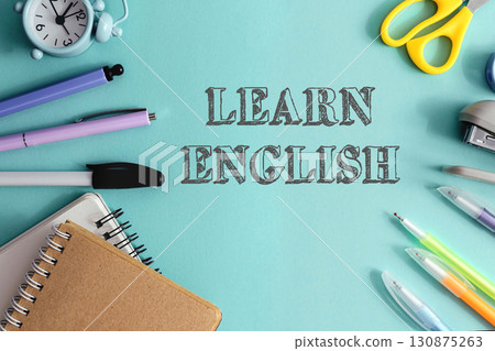 A blue background with a clock, scissors, pens, and pencils A blue background with a clock, scissors, pens, and pencils 130875263
