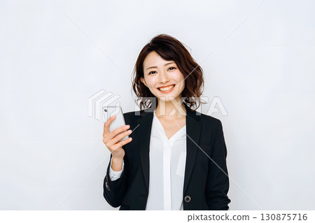 Japanese woman holding a smartphone. Portrait of a smiling business person 130875716