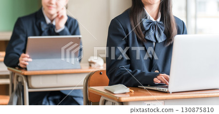 Junior high and high school girls in uniforms studying using computers and tablets Junior high and high school girls in uniforms studying using computers and tablets 130875810