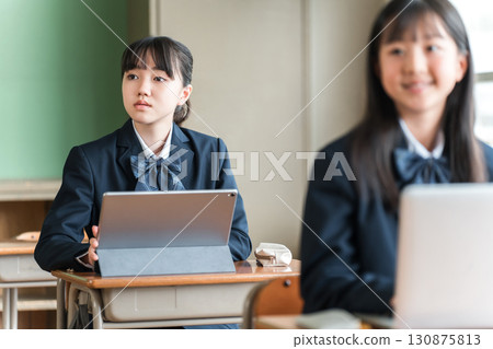 穿著校服的國中和高中女生使用電腦和平板電腦學習 130875813