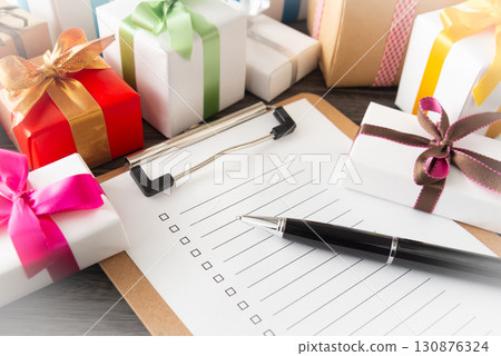 Checklist and gift box, shopping list, writing out gifts to prepare 130876324