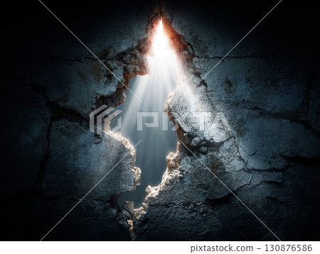 Light beams shining through hole in cracked concrete wall symbolizing hope and new beginning Light beams shining through hole in cracked concrete wall symbolizing hope and new beginning 130876586