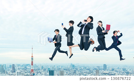 一群商務人士在城市背景下用數位設備跳躍 一群商務人士在城市背景下用數位設備跳躍 130876722