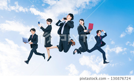 藍天背景下，一群商務人士用數位設備跳躍 130876724