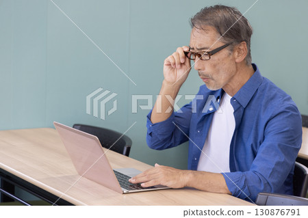 患有老花眼的老人正在使用電腦 患有老花眼的老人正在使用電腦 130876791