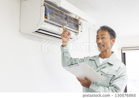 Senior male repairman checking air conditioner 130876868