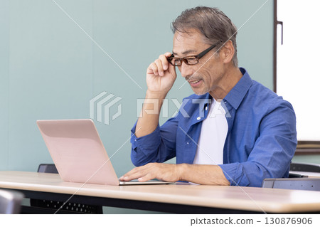 Senior man with presbyopia using a computer 130876906