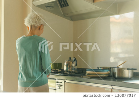 Elderly woman standing in the kitchen 130877017