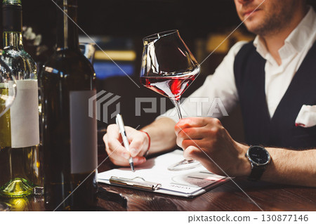 Sommelier studies assortment of alcoholic drinks of restaurant. 130877146