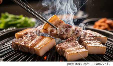 Korean Samgyeopsal Pork Belly Grilling with Chopsticks Close Up 130877319