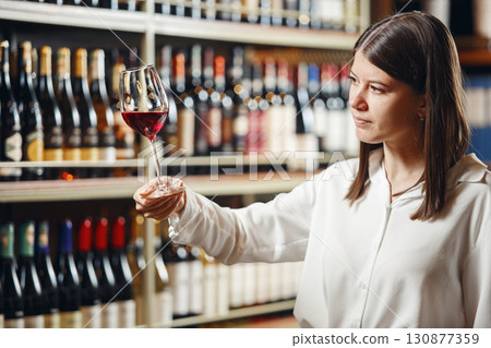 Professional caucasian woman sommelier checking wine quality and compare the data for taste. Professional caucasian woman sommelier checking wine quality and compare the data for taste. 130877359