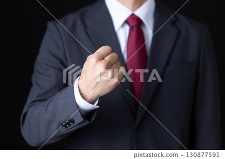 Middle-aged male businessman in a suit making a fist pump 130877591