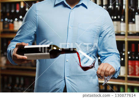 Close-Up of Sommelier Pouring Red Wine Into Glass in Wine Cellar Close-Up of Sommelier Pouring Red Wine Into Glass in Wine Cellar 130877614