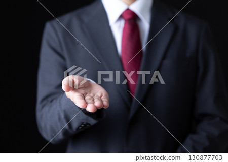 一位身穿西裝的中年男性商人伸出一隻手 一位身穿西裝的中年男性商人伸出一隻手 130877703