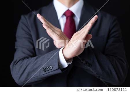 一位身著西裝的中年男性商人做出十字手勢 130878111