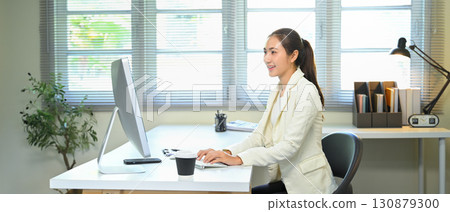 Professional businesswoman working on desktop computer at modern office desk Professional businesswoman working on desktop computer at modern office desk 130879300
