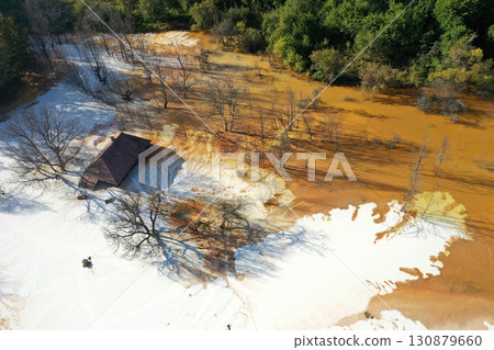 Aerial view of sinking village house in the middle of toxic mine decanting lake Aerial view of sinking village house in the middle of toxic mine decanting lake 130879660