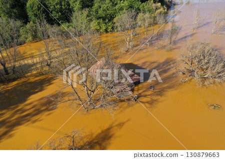 Aerial view of sinking village house in the middle of toxic mine decanting lake Aerial view of sinking village house in the middle of toxic mine decanting lake 130879663