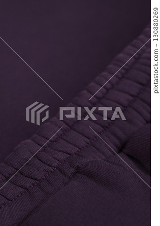 Warm dark purple tracksuit. Close-up of elastic waistband. Textile warm fabric macro. Warm dark purple tracksuit. Close-up of elastic waistband. Textile warm fabric macro. 130880269