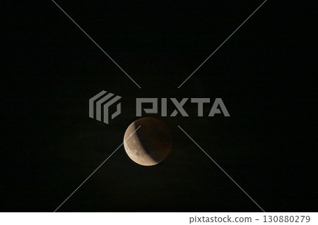 Lunar eclipse beginning close-up right corner sun begins to come on top of moon lunar eclipse black background at night Lunar eclipse beginning close-up right corner sun begins to come on top of moon lunar eclipse black background at night 130880279