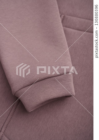 Sweatshirt texture. Close-up of the sleeve of a light brown sweatshirt. Cotton. Warm textile fabric, macro photography. Sweatshirt texture. Close-up of the sleeve of a light brown sweatshirt. Cotton. Warm textile fabric, macro photography. 130880396