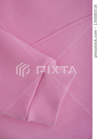 Texture of a hoodie. Close-up of the sleeve of a pink hoodie. Warm textile fabric, macro. Texture of a hoodie. Close-up of the sleeve of a pink hoodie. Warm textile fabric, macro. 130880516